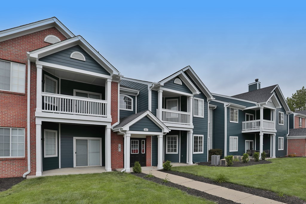 A row of townhouses with balconies and front yards.