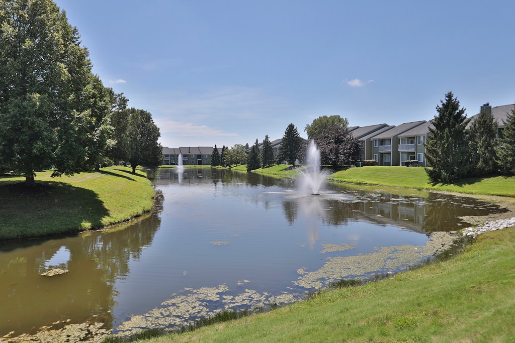 A pond with a fountain in the middle of it.