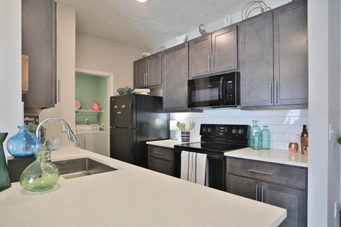 a kitchen with black appliances and a white counter top