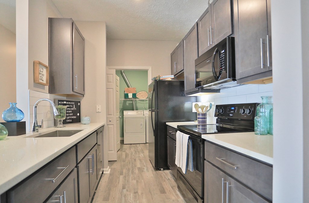 an open kitchen with stainless steel appliances and wood flooring
