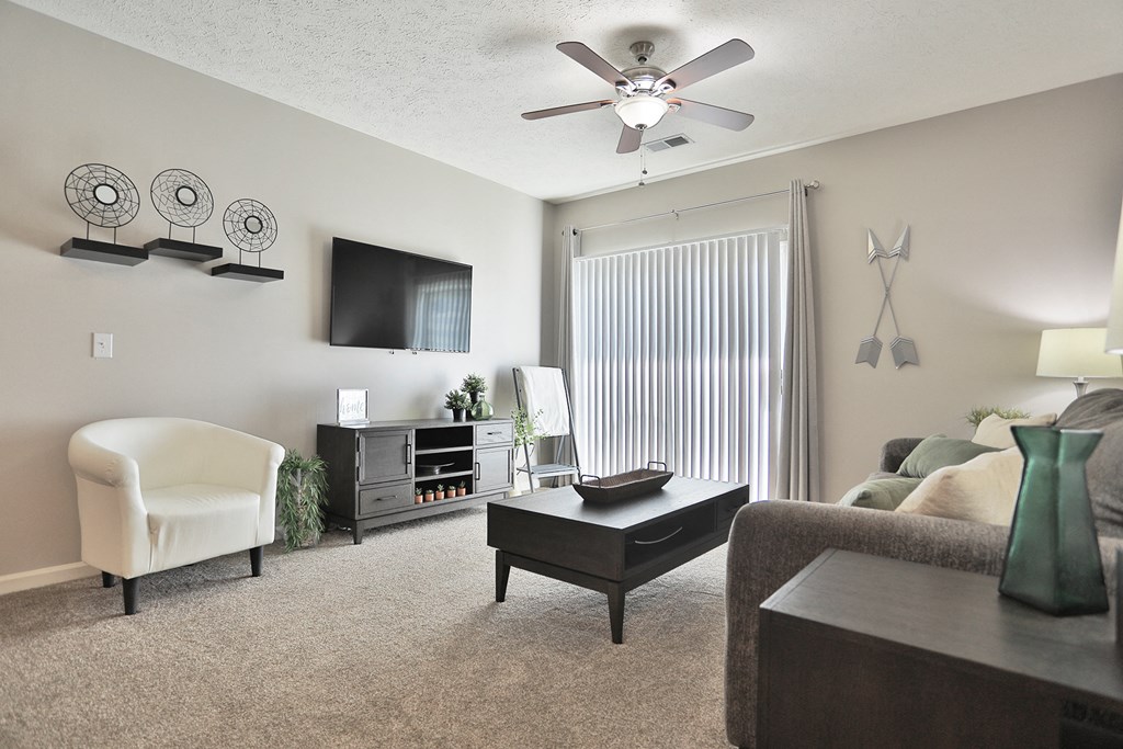 an open living room with a ceiling fan and a large window
