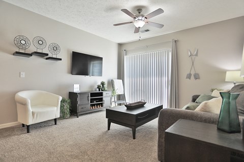 an open living room with a ceiling fan and a large window