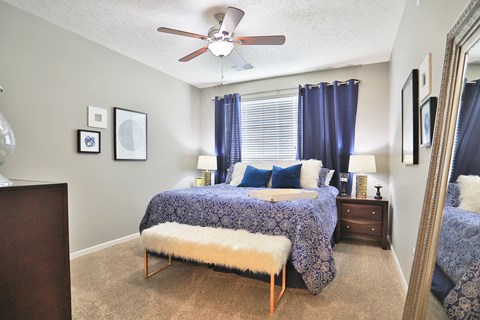 a bedroom with a bed and a ceiling fan