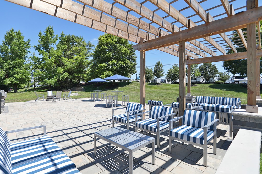 A patio with blue and white striped chairs and a table.