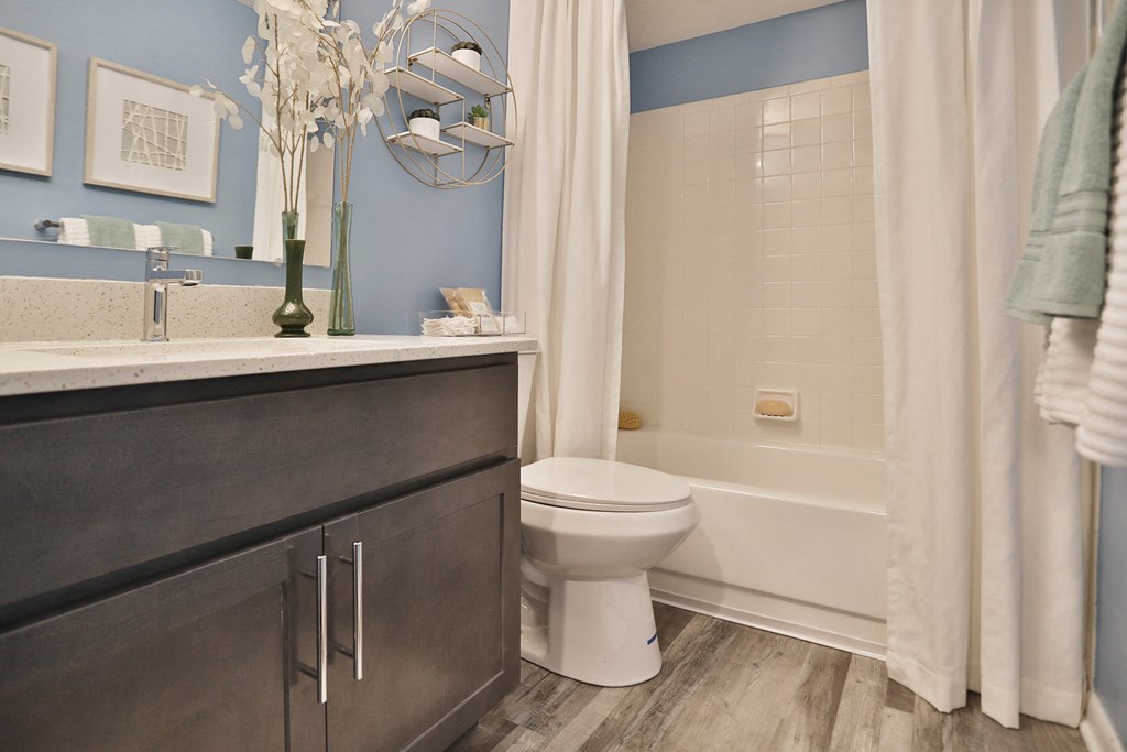 a bathroom with a toilet and a shower and a sink