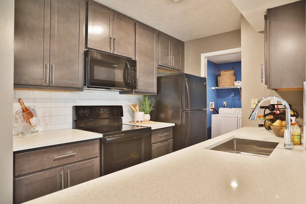 a kitchen with stainless steel appliances and white counter tops