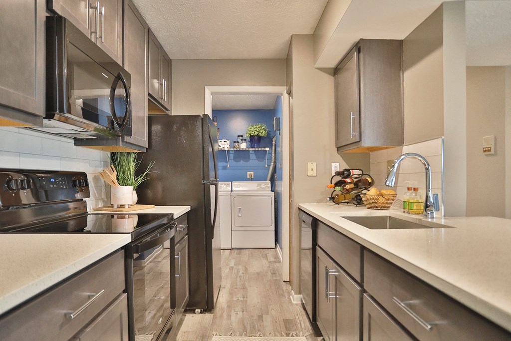 a kitchen with stainless steel appliances and white counter tops