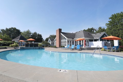 A swimming pool with a house in the background.