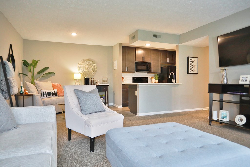 a living room and kitchen with a couch and a chair