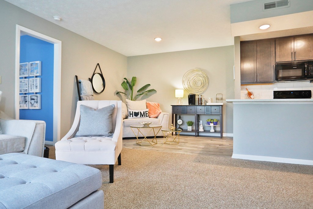 an open living room and kitchen with a couch and chairs