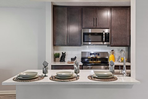 A modern kitchen with brown cabinets and a white countertop.
