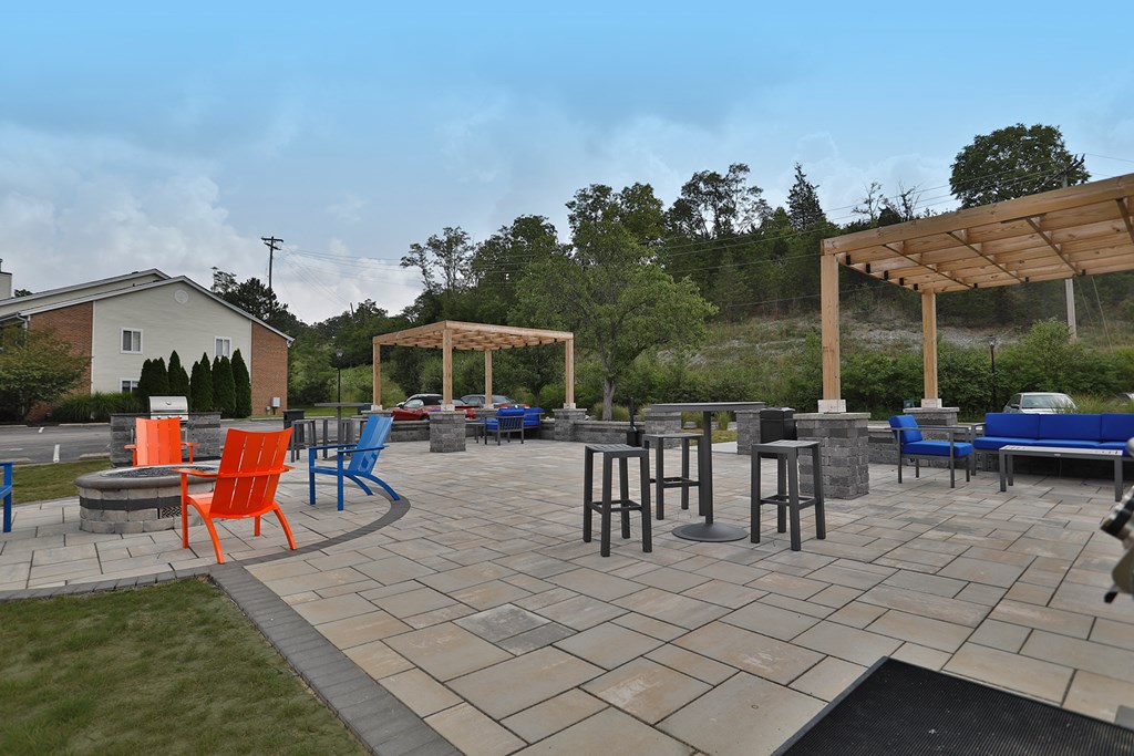 a patio with chairs and tables and a pergola