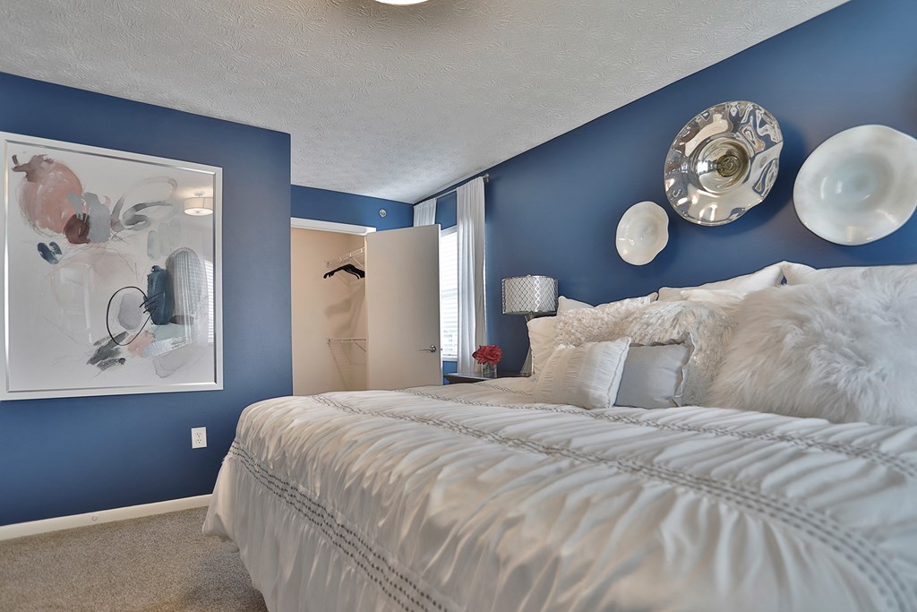 a blue and white bedroom with a bed and blue walls