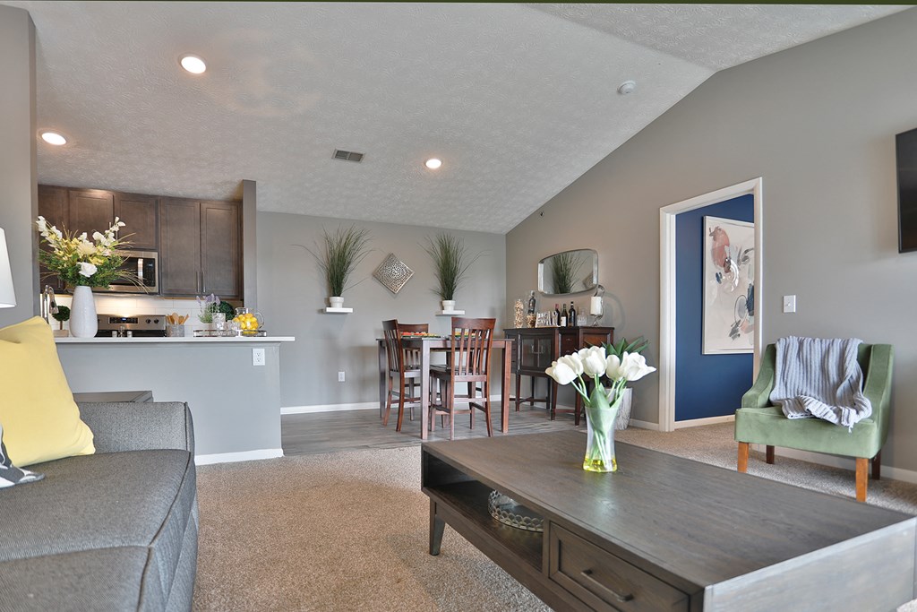 a living room with a couch and a table with flowers