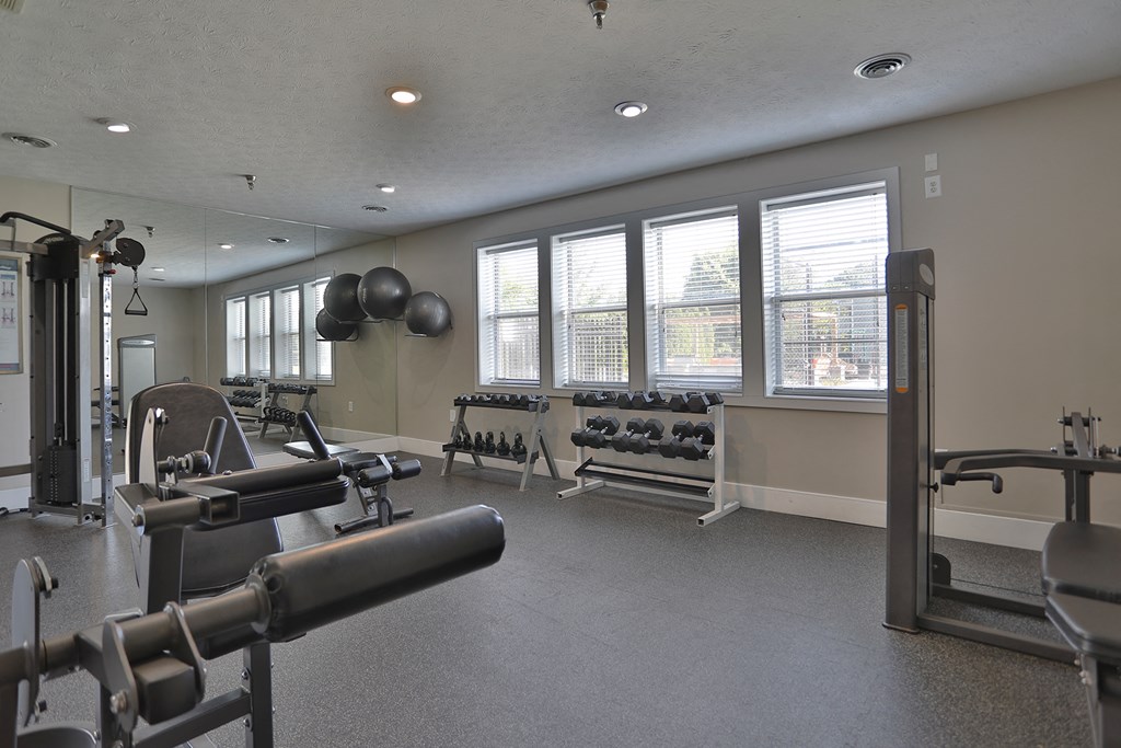 a gym with weights and other exercise equipment and windows