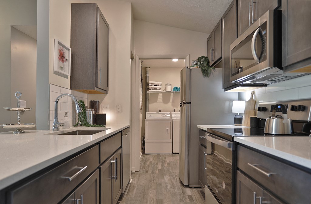 spacious kitchen with stainless steel appliances and white quartz counter tops at the reserve at south
