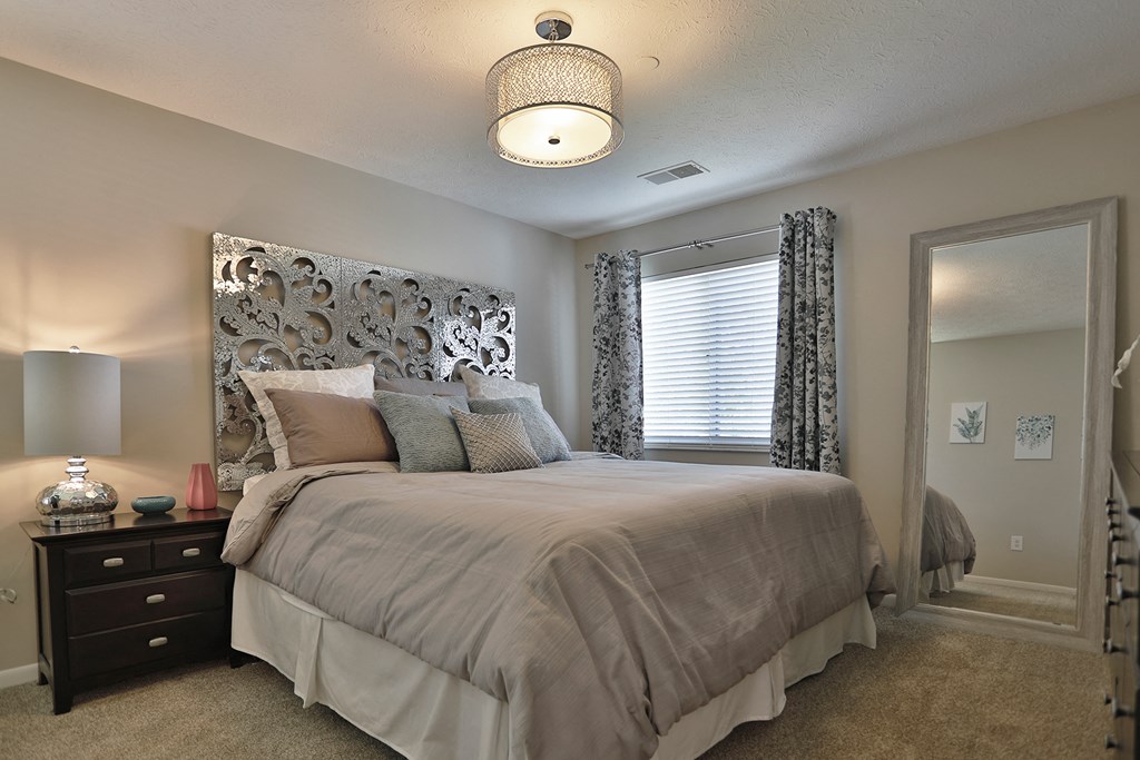 a bedroom with a large bed and a window