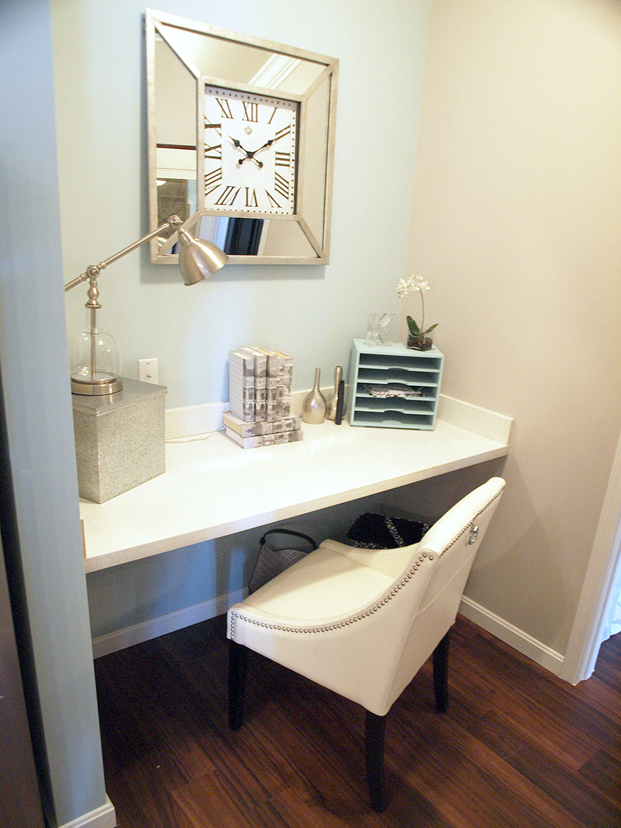 a white desk with a chair and a clock on the wall