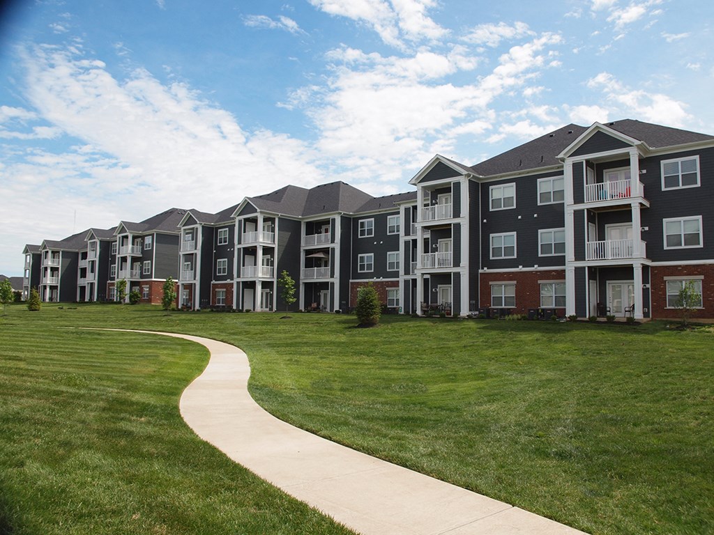 an exterior view of an apartment building with a sidewalk