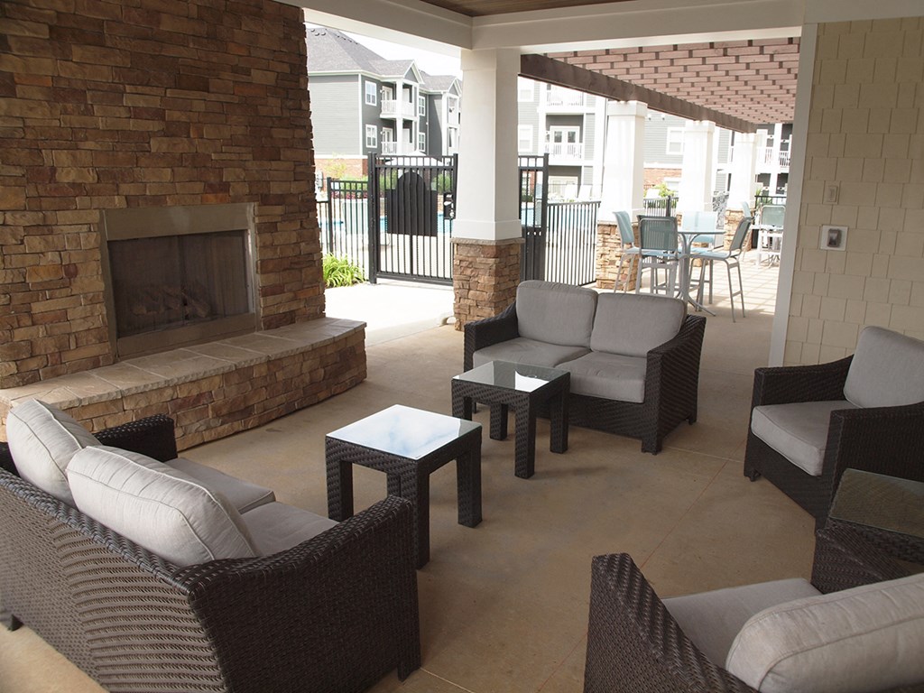 a patio with couches and tables and a fireplace