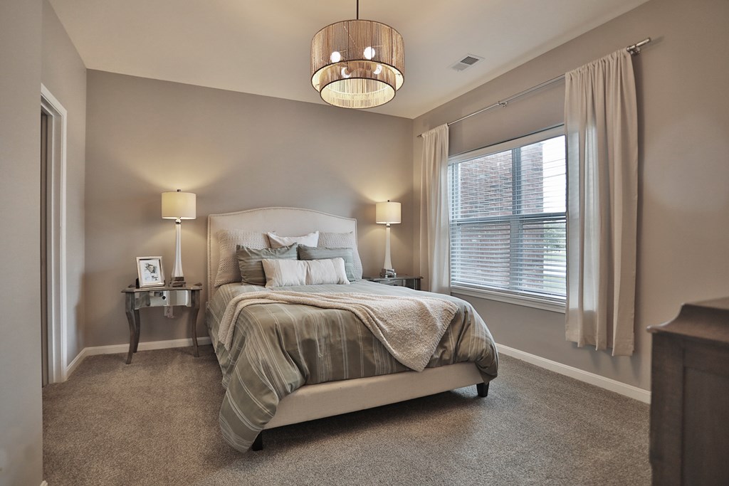 A bedroom with a large bed and a chandelier.