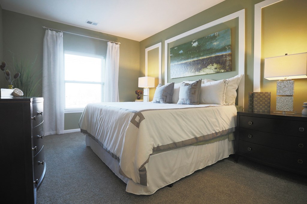 a bedroom with a bed and a painting on the wall