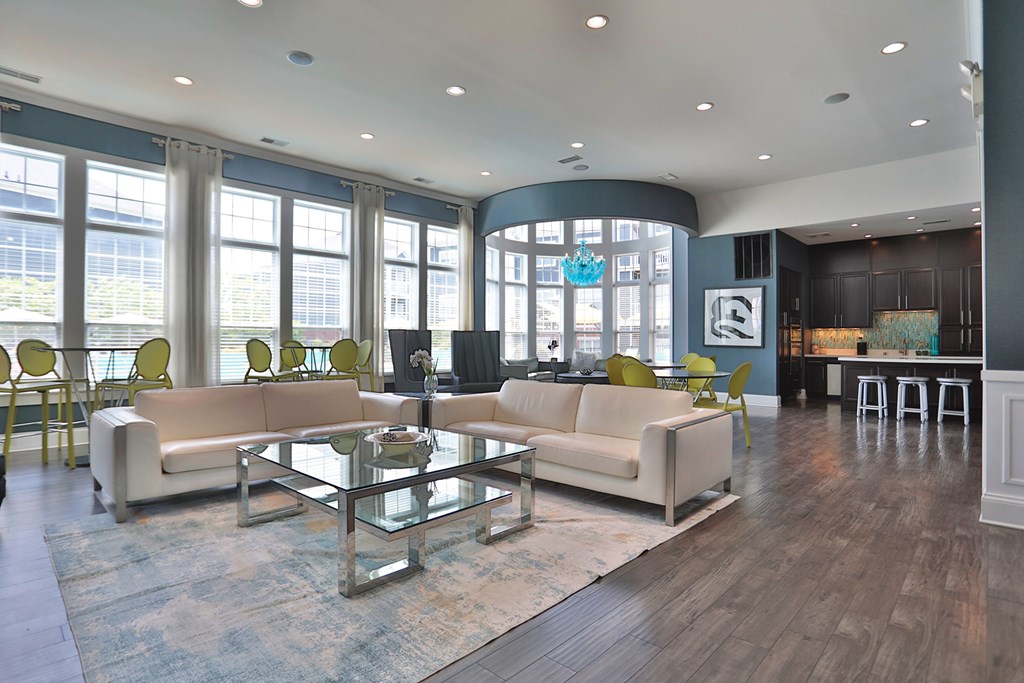 A spacious living room with a glass table and white couches.