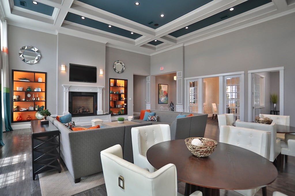 A large, well-lit dining room with a fireplace and a variety of seating options.