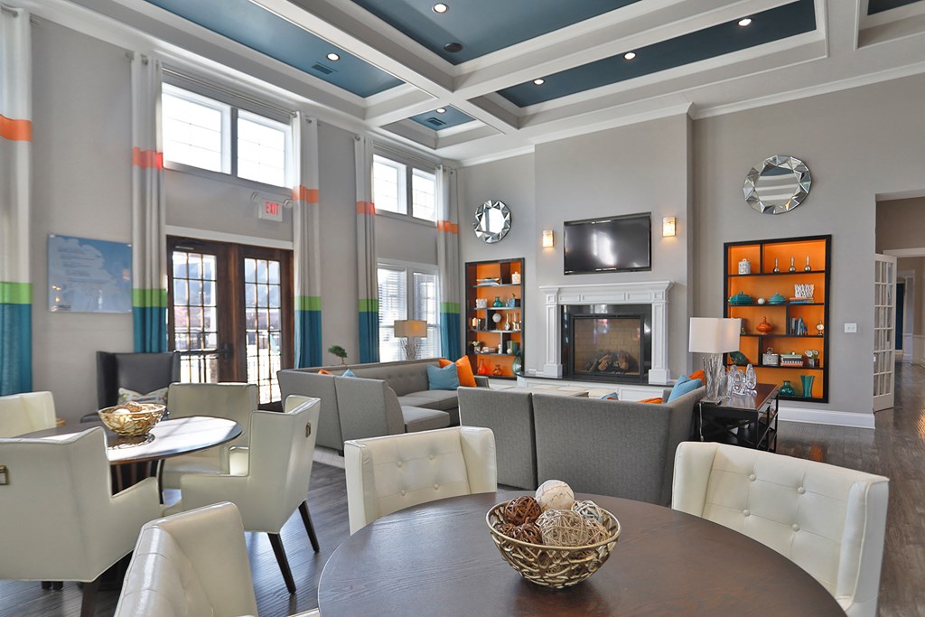 a large living room with a table and chairs and a fireplace