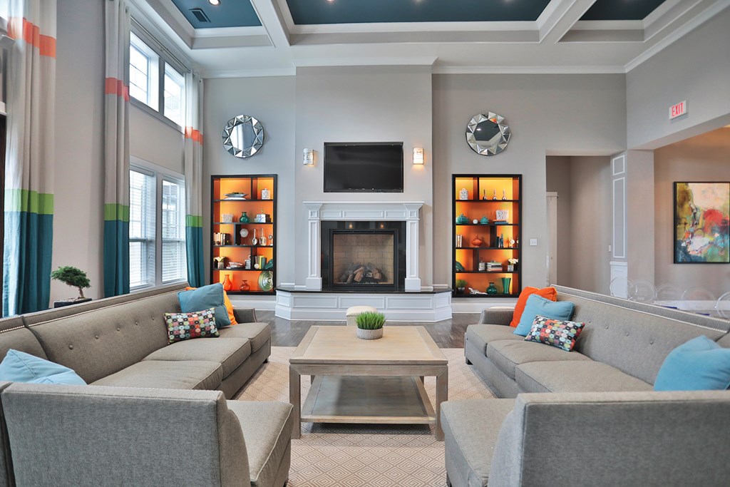 A living room with a grey couch and a fireplace.