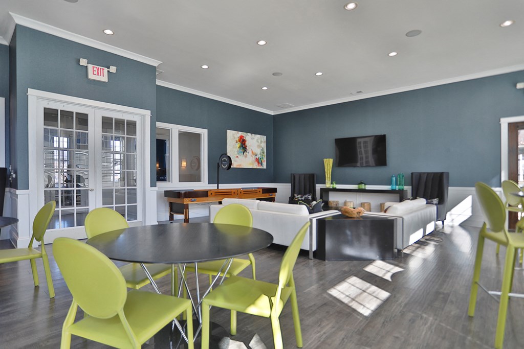a living room with blue walls and yellow chairs and tables