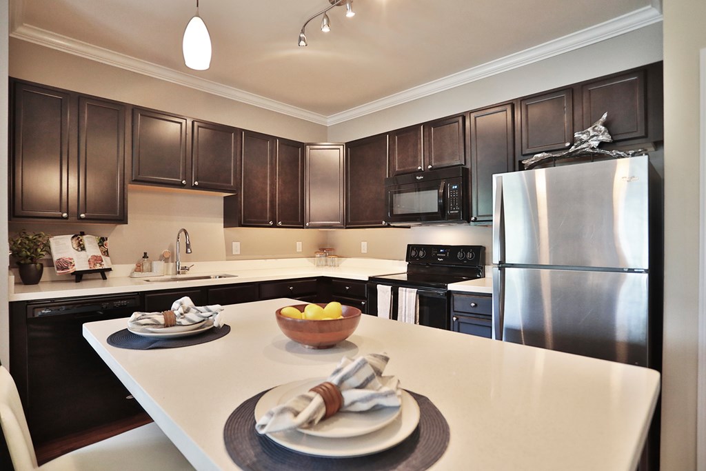 A modern kitchen with a white countertop and black cabinets.