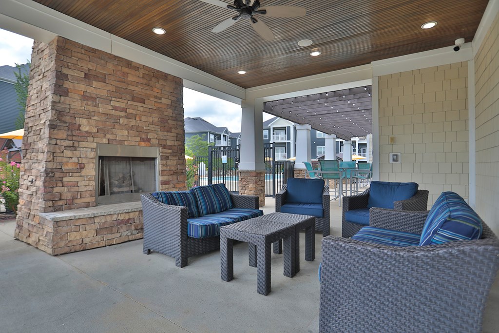 A patio with a stone fireplace and furniture.