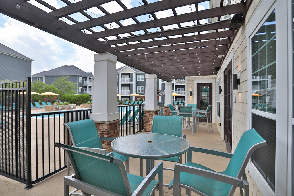 A patio with a table and chairs under a pergola.