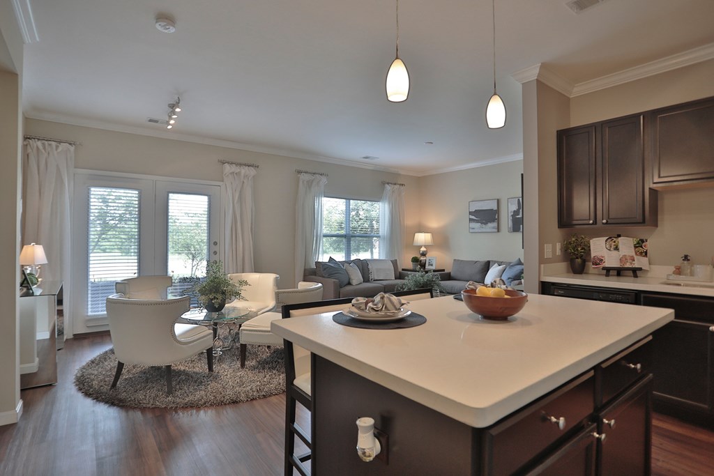A modern kitchen with a white island and dark wood cabinets.