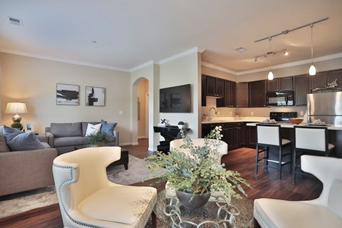 A modern living room with a grey couch, a white chair, and a coffee table with a plant on it.