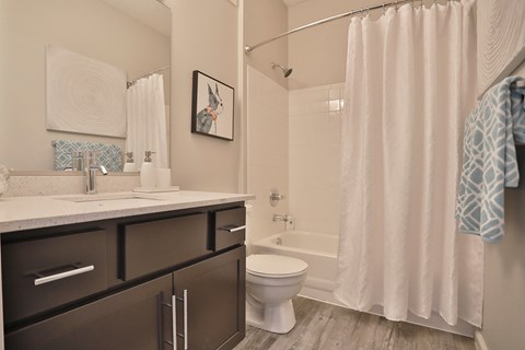 A bathroom with a white shower curtain and a white toilet.