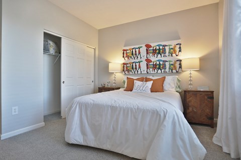 A bedroom with a white bed and a white wall.