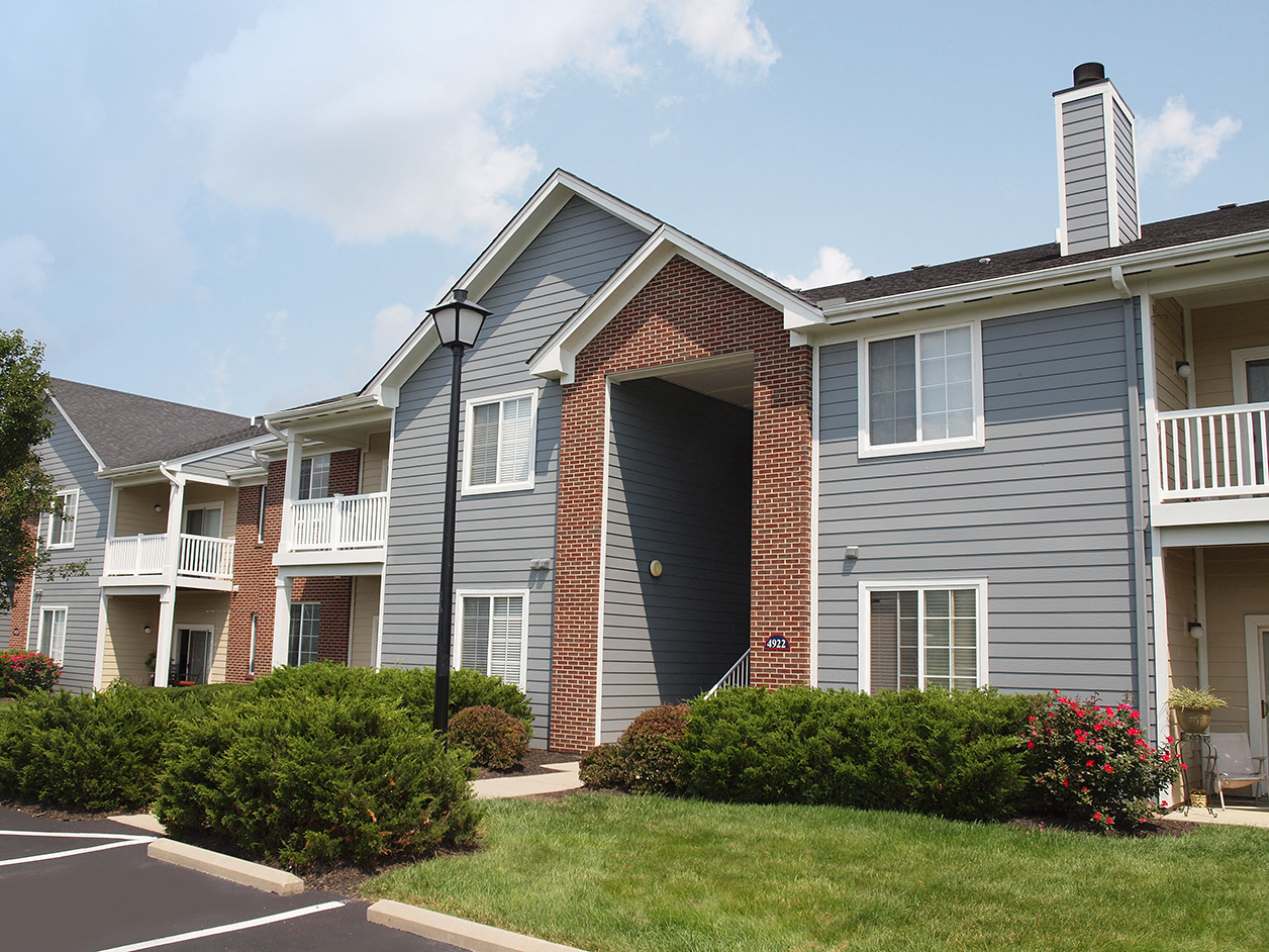 an apartment building with blue siding and red brick