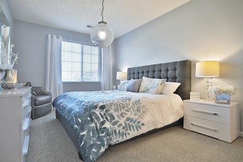 A bedroom with a large bed and a nightstand.