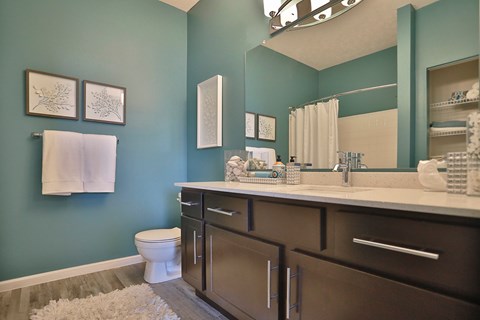 A bathroom with a toilet, sink, and mirror.