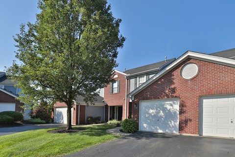 A red brick house with a white garage door.