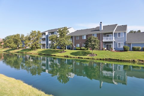 A serene lake in front of a row of houses.