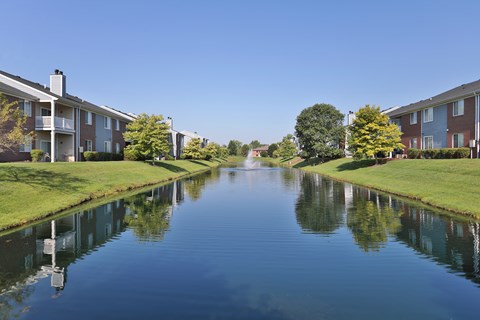 A row of houses with a body of water in front of them.