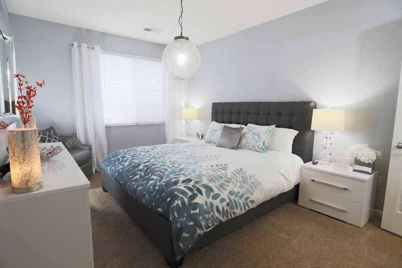 a bedroom with a bed and a night stand and a window