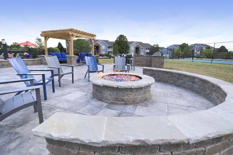 an outdoor patio with a fire pit and chairs and a gazebo