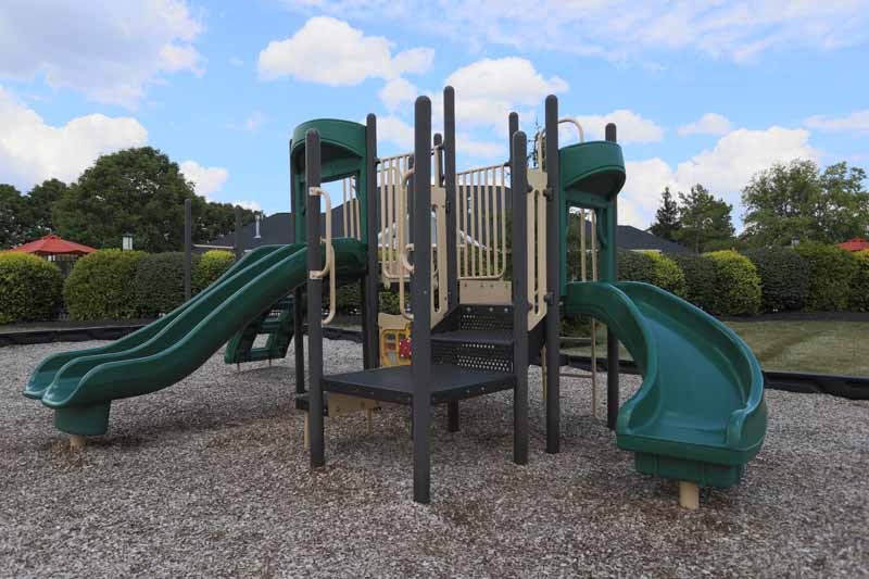 a playground with slides and benches in a park