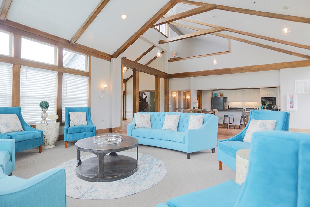 a living room with blue couches and chairs and a table