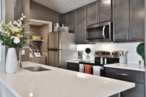 a kitchen with stainless steel appliances and a white counter top