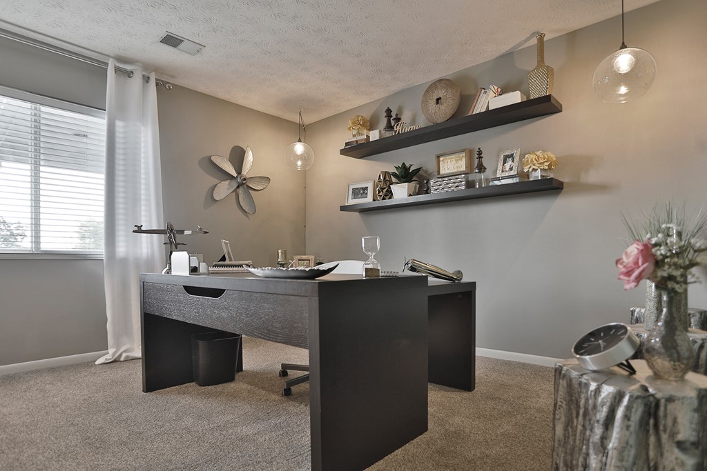 a home office with a large desk and a large window